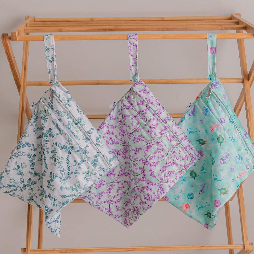 3 NappyLuxe wet bags hanging neatly on wooden clothes horse