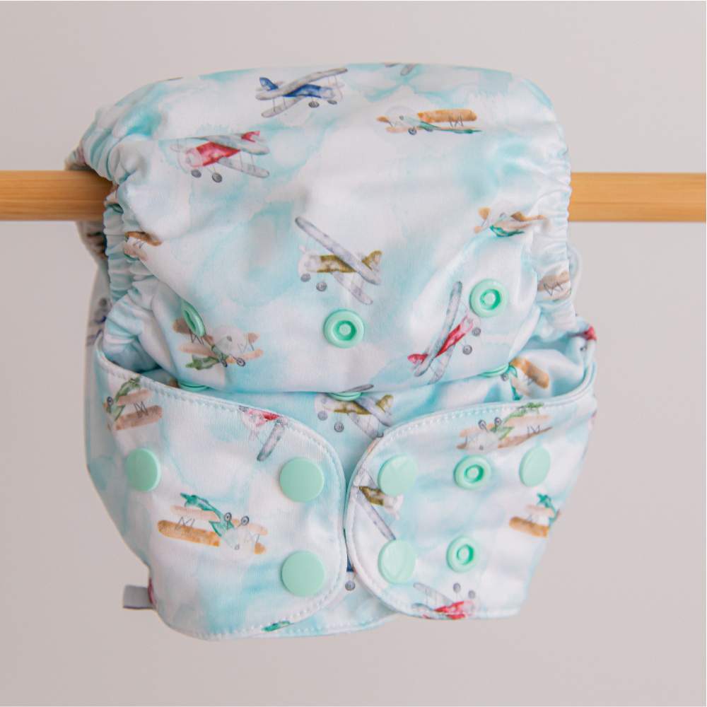 Blue planes in flight reusable nappy hanging from wooden pole