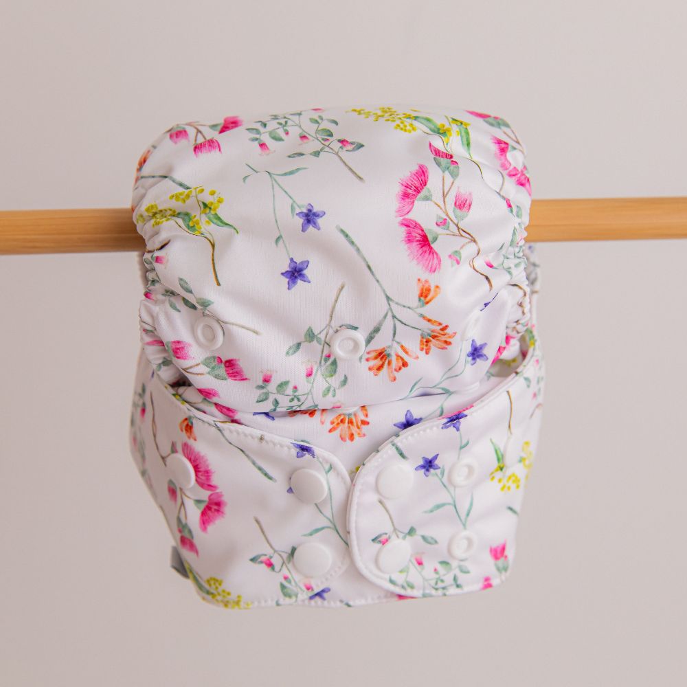 Australian floral washable nappy hanging on wooden rail
