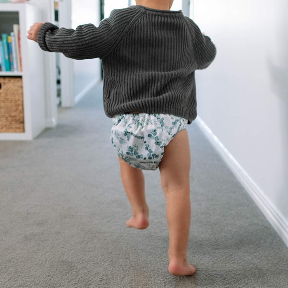 Toddler running wearing knitted jumper and reusable nappy
