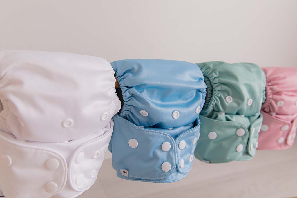 Shot of white, blue, green and pink cloth nappies in a row